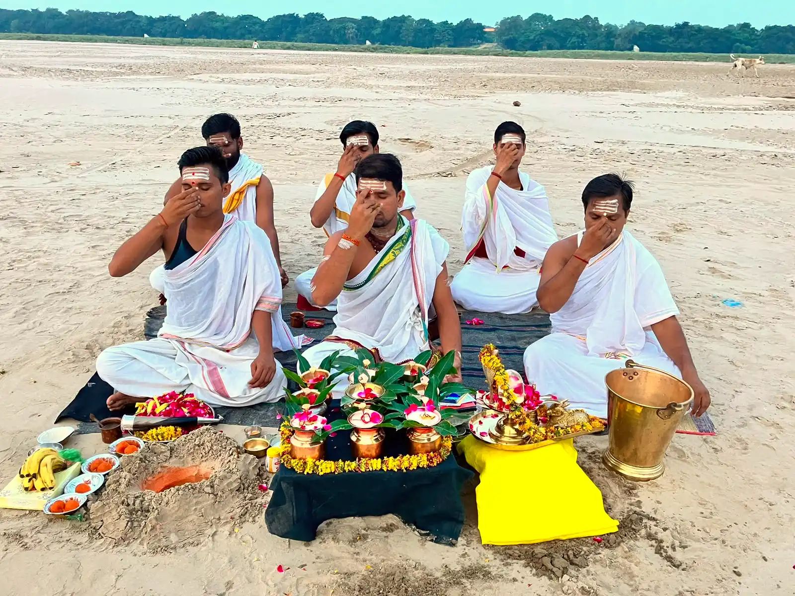 Priests performing a Vedic Yagya at sunset on the banks of the river in Prayagraj